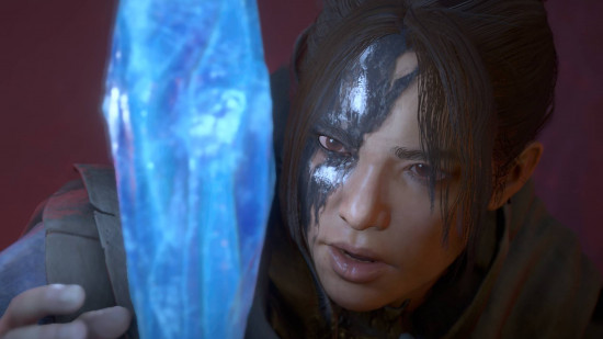 Diablo 4 Vessel of Hatred review: A young, dark haired woman with inky blackness on the right-hand side of her face reaches out to a blue, glowing crystal